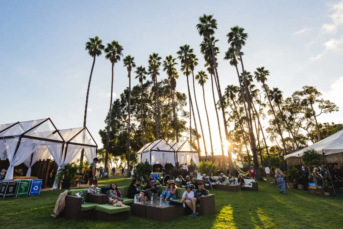 Outdoor VIP lounge beneath palm trees at Ohana Festival in Dana Point