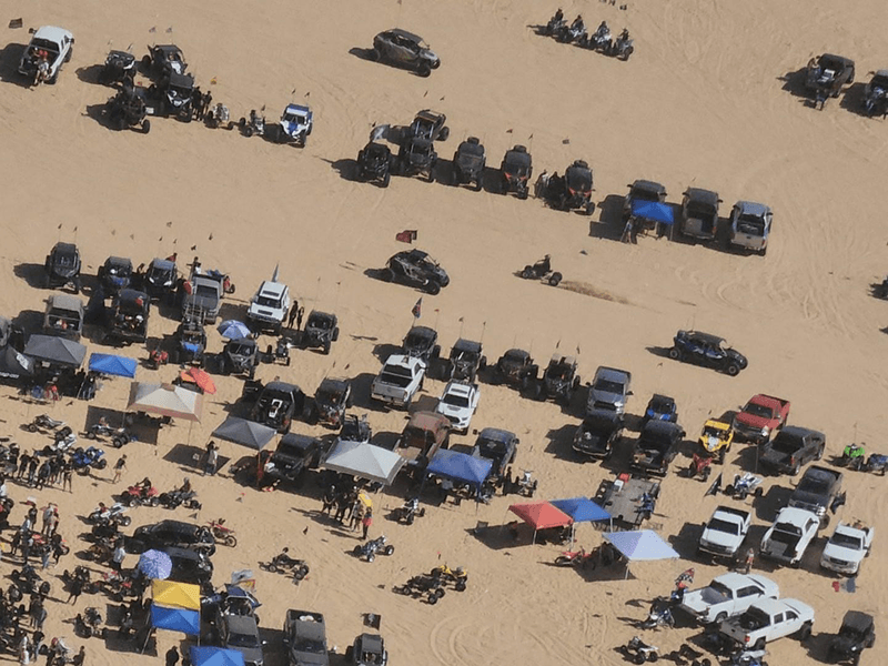 Overhead view of a desert camp with trailers and side-by-sides