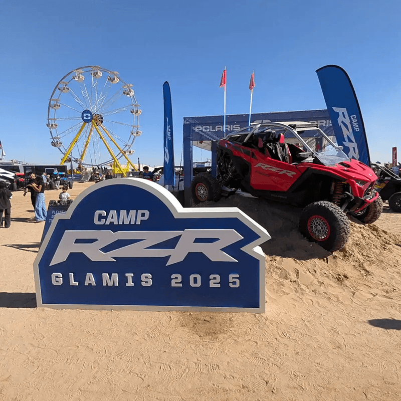 Camp RZR Glamis 2025 sign beside a Polaris display vehicle