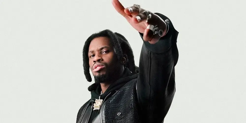 Denzel Curry posing with one arm raised